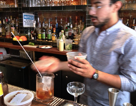 Wilmer Nolasco, a server and bartender at 'Cue in the West Village, makes a fat-washed Rye Manhattan. Photo by Donna Turner Ruhlman.